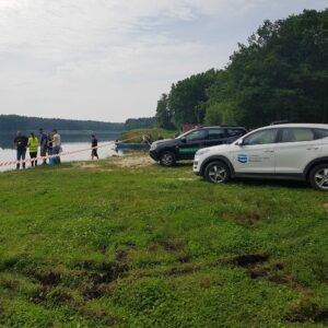 pobór wody do badań, samochody nad brzegiem jeziora